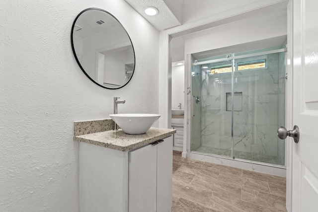 3005 Club Hill Dr, Garland, TX 75043 - full bath featuring a marble finish shower, vanity, and a textured wall