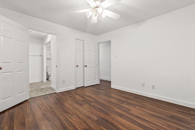 3005 Club Hill Dr, Garland, TX 75043 - unfurnished bedroom with dark wood-type flooring, ceiling fan, baseboards, ensuite bathroom, and a textured ceiling