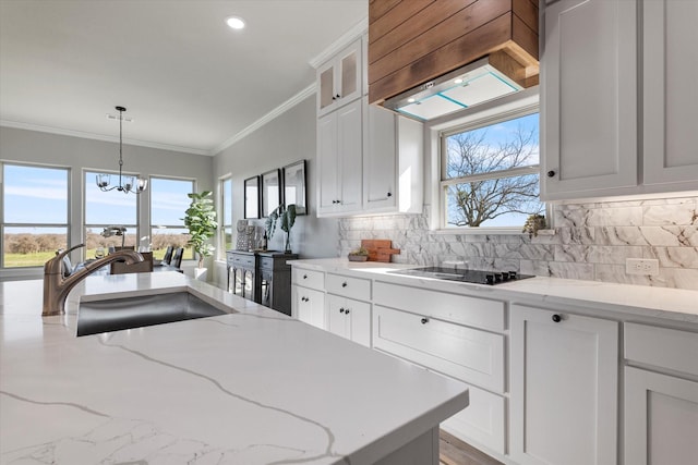 kitchen featuring tasteful backsplash, premium range hood, ornamental molding, black electric cooktop, and a sink
