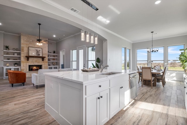 kitchen featuring light wood finished floors, visible vents, dishwasher, and a sink