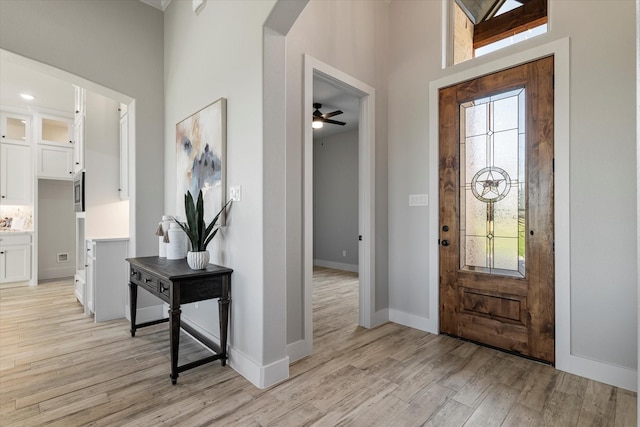 entrance foyer with light wood finished floors, ceiling fan, and baseboards