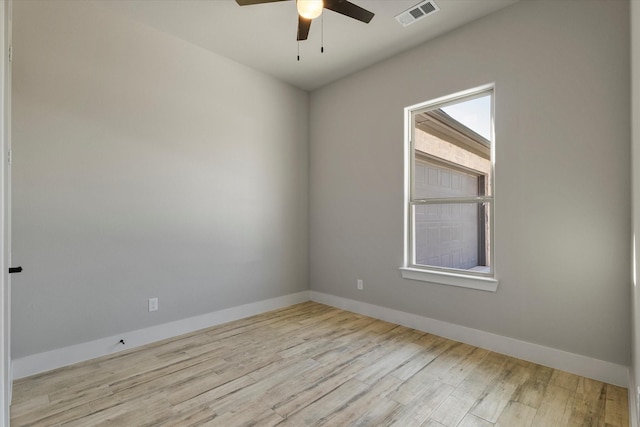spare room featuring visible vents, baseboards, ceiling fan, and wood finished floors