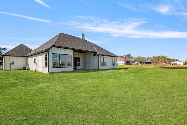 back of house featuring cooling unit, a lawn, board and batten siding, and a shingled roof