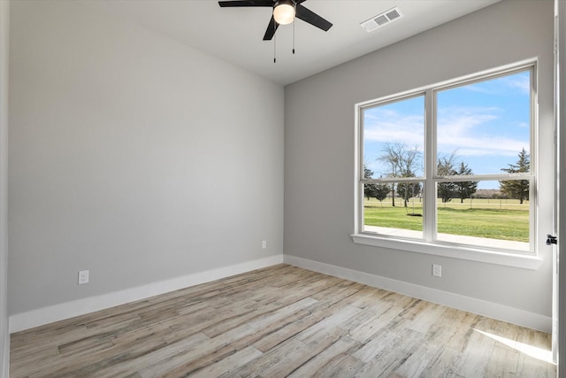 unfurnished room with visible vents, baseboards, a ceiling fan, and wood finished floors