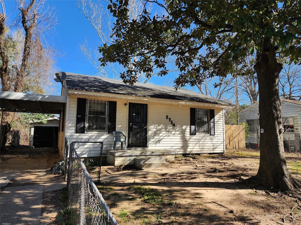 bungalow featuring fence and an attached carport