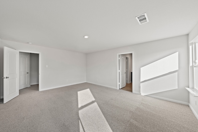 spare room featuring carpet flooring, baseboards, and visible vents