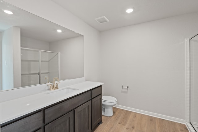 full bath with visible vents, a shower stall, baseboards, toilet, and wood finished floors