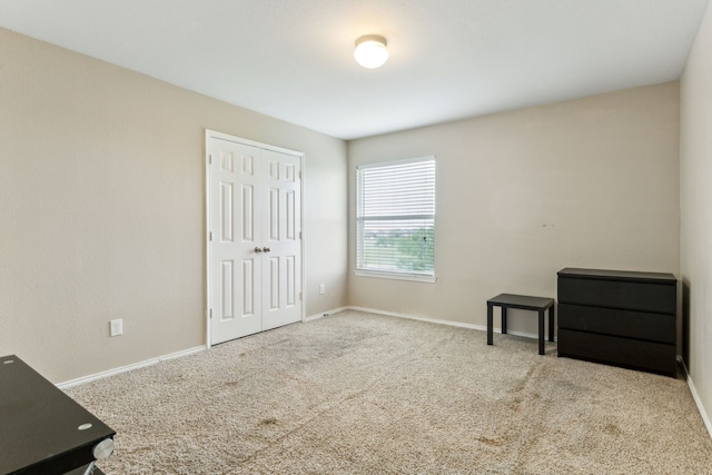 unfurnished bedroom featuring a closet, carpet, and baseboards