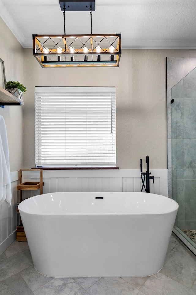 104 Petes Ln, Ponder, TX 76259 - full bathroom featuring ornamental molding, marble look tile flooring, a stall shower, a soaking tub, and a wainscoted wall