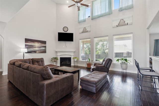 140 Dogwood Dr, Krugerville, TX 76227 - living room with baseboards, a towering ceiling, dark wood-style floors, a glass covered fireplace, and a ceiling fan