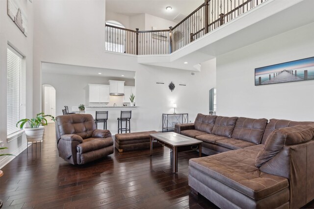 140 Dogwood Dr, Krugerville, TX 76227 - living area featuring dark wood-style floors, arched walkways, a towering ceiling, and baseboards