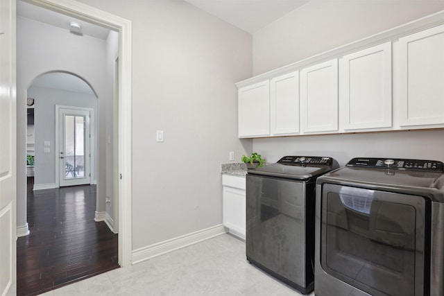 140 Dogwood Dr, Krugerville, TX 76227 - laundry area featuring arched walkways, independent washer and dryer, cabinet space, and baseboards