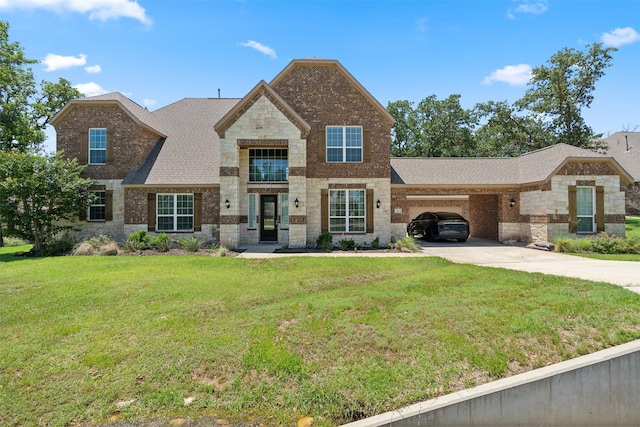 140 Dogwood Dr, Krugerville, TX 76227 - view of front of home with driveway, an attached garage, a shingled roof, a front lawn, and stone siding