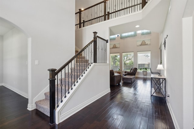 140 Dogwood Dr, Krugerville, TX 76227 - staircase with arched walkways, a high ceiling, baseboards, and wood finished floors