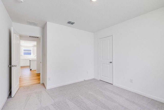empty room with carpet flooring, baseboards, and visible vents