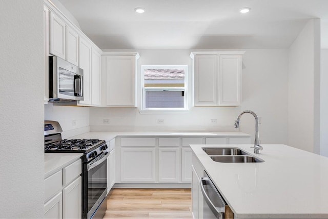 kitchen featuring a sink, light countertops, white cabinetry, and stainless steel appliances