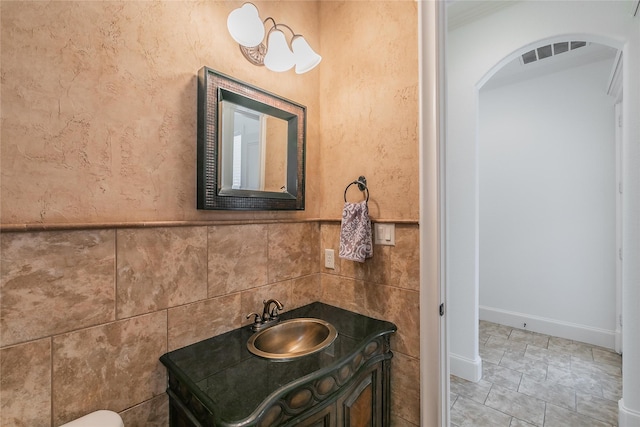 bathroom featuring vanity, tile walls, visible vents, and tile patterned flooring