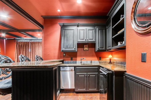 kitchen with light wood finished floors, a sink, a wainscoted wall, recessed lighting, and open shelves