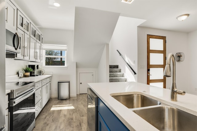 3725 Toronto St, Dallas, TX 75212 - kitchen with light wood-type flooring, light countertops, appliances with stainless steel finishes, blue cabinets, and a sink