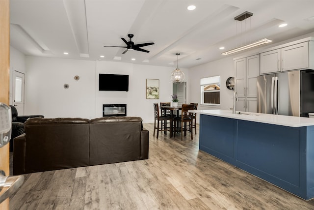 3725 Toronto St, Dallas, TX 75212 - living room featuring light wood finished floors, a glass covered fireplace, recessed lighting, and ceiling fan