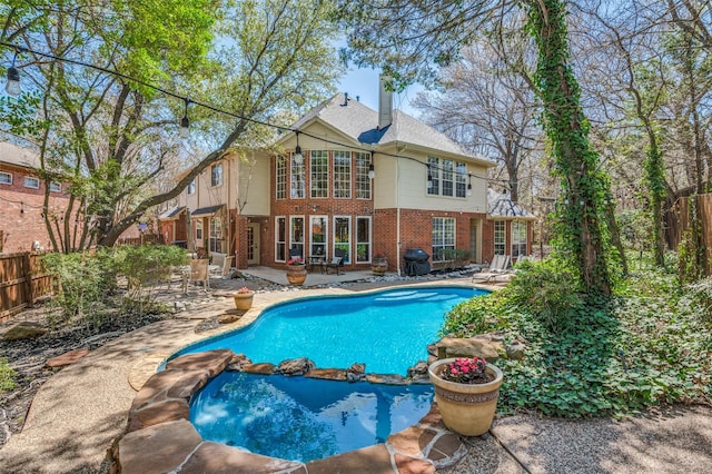 313 Appalachian Way, Mckinney, TX 75071 - rear view of property featuring a chimney, brick siding, a pool with connected hot tub, a patio area, and a fenced backyard
