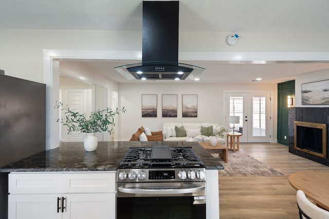 6410 Symphony Ln, Dallas, TX 75227 - kitchen featuring gas stove, island exhaust hood, refrigerator, white cabinetry, and open floor plan