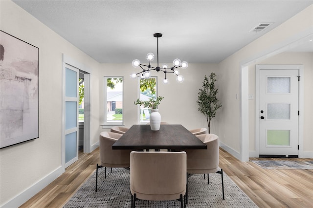 6410 Symphony Ln, Dallas, TX 75227 - dining space featuring a chandelier, light wood-style floors, and baseboards