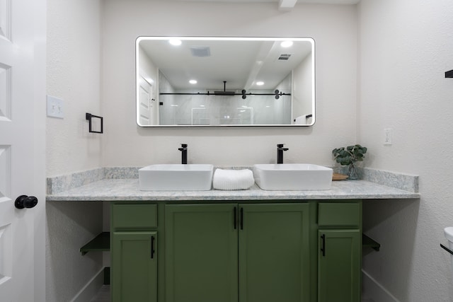 full bath with double vanity, visible vents, a stall shower, and a sink