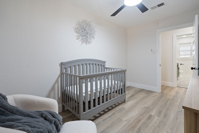 bedroom with visible vents, ceiling fan, light wood finished floors, and baseboards