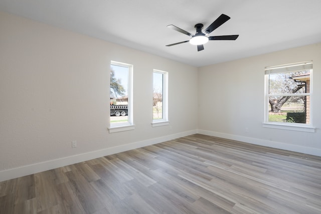 unfurnished room featuring baseboards, wood finished floors, and a ceiling fan