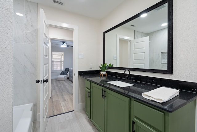 bathroom featuring connected bathroom, visible vents, a bathtub, and vanity
