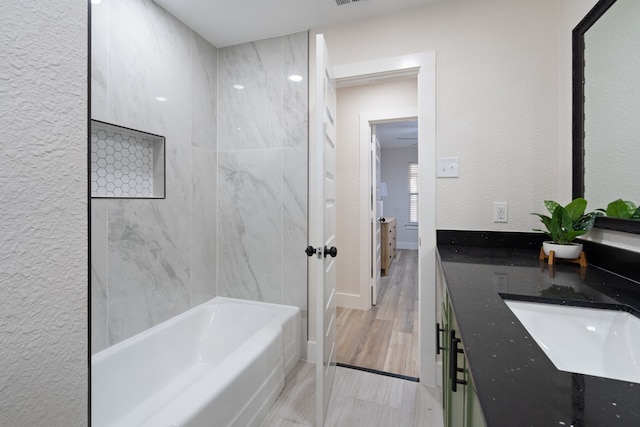 bathroom with double vanity, a bathtub, and a sink