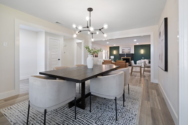 dining room featuring a chandelier, wood finished floors, and baseboards