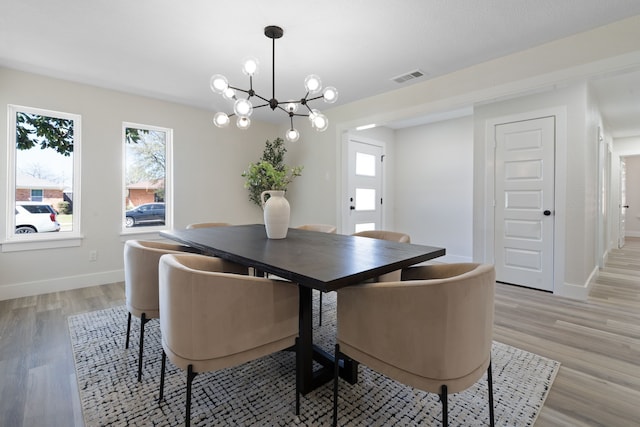 dining room featuring light wood-style floors, visible vents, plenty of natural light, and baseboards