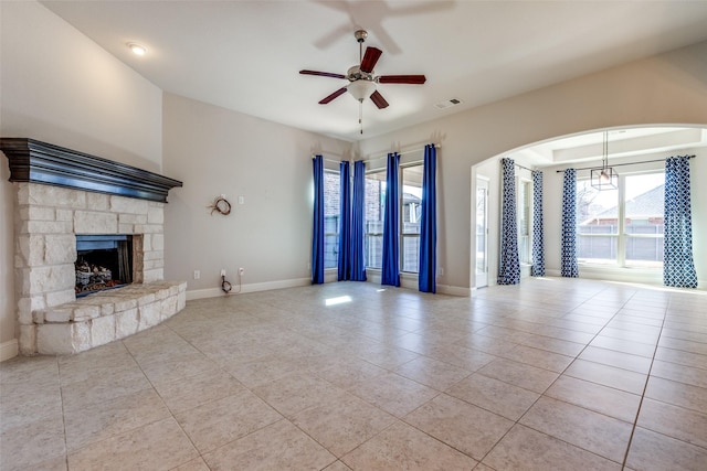 816 Sandbox Dr, Little Elm, TX 76227 - unfurnished living room with tile patterned floors, a ceiling fan, a fireplace, and arched walkways