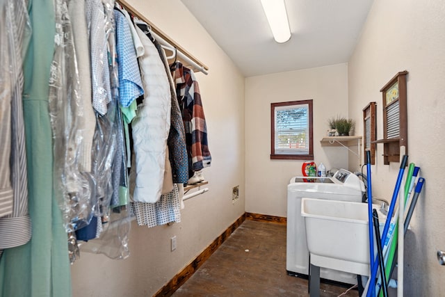 laundry room featuring wood finished floors, baseboards, laundry area, a sink, and washer and clothes dryer