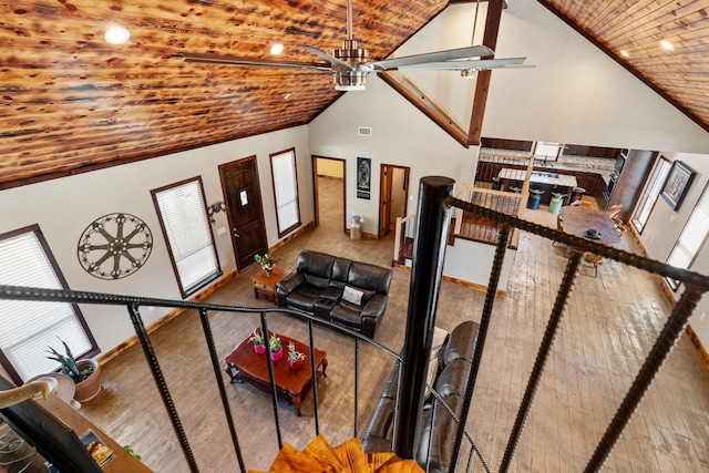 living room with visible vents, baseboards, high vaulted ceiling, and wood ceiling