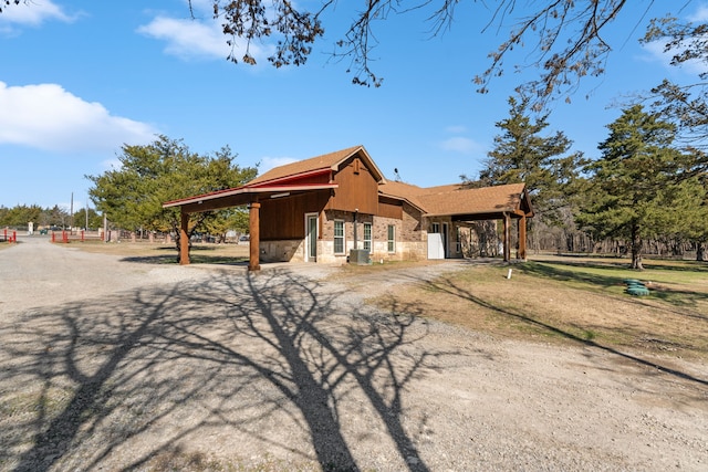 view of front facade featuring stone siding and a shingled roof