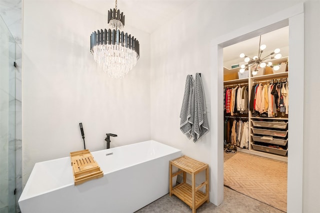 bathroom with a freestanding tub, a chandelier, and a spacious closet