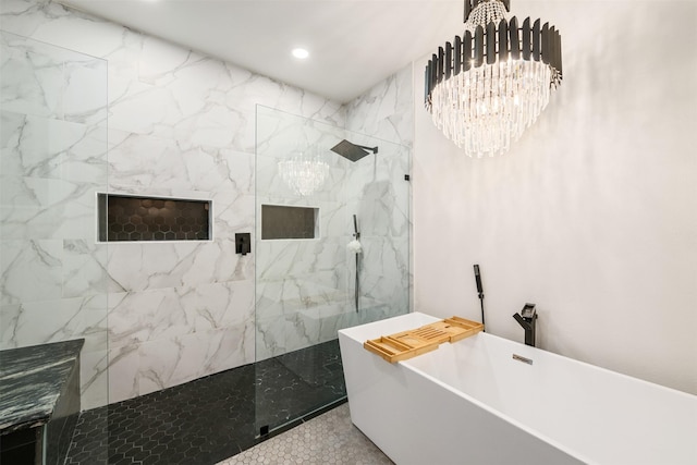 bathroom with a marble finish shower, recessed lighting, an inviting chandelier, and a freestanding tub