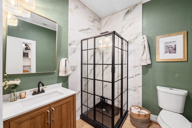 full bath with visible vents, toilet, a stall shower, a textured wall, and vanity