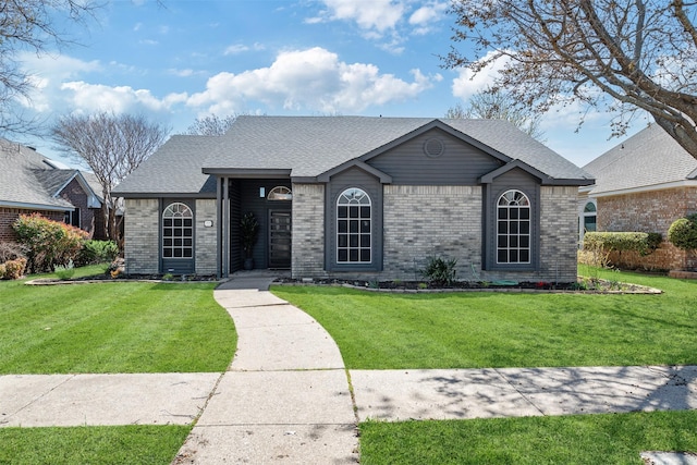 ranch-style house with a front yard and brick siding