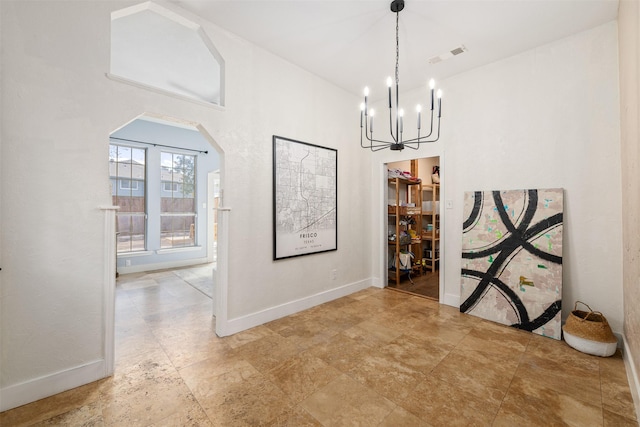 unfurnished dining area with a notable chandelier, visible vents, arched walkways, and baseboards