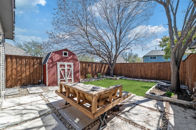 view of patio featuring outdoor dining space, an outbuilding, a storage unit, and a fenced backyard
