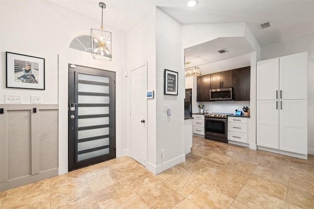 foyer entrance featuring visible vents and an inviting chandelier