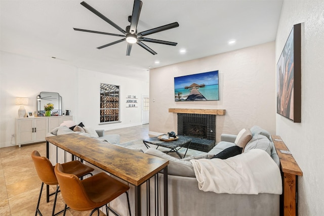 living area with recessed lighting, baseboards, ceiling fan, and a fireplace