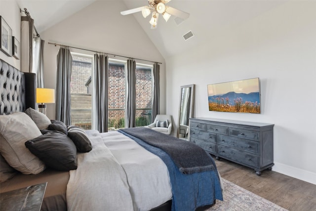 bedroom featuring baseboards, a ceiling fan, visible vents, high vaulted ceiling, and wood finished floors