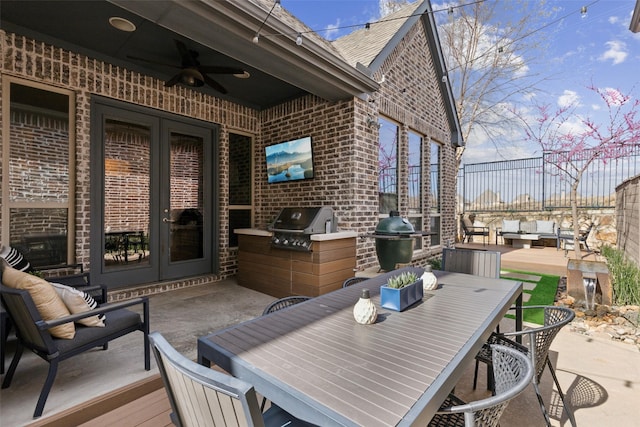 view of patio with french doors, exterior kitchen, and outdoor dining space