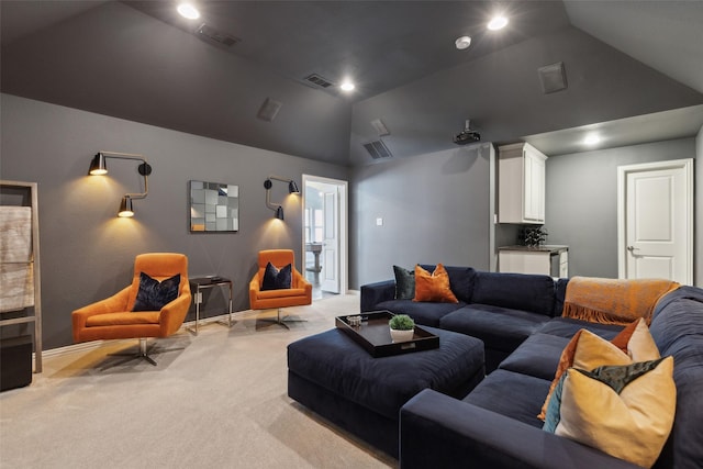 home theater room with visible vents, light colored carpet, and vaulted ceiling