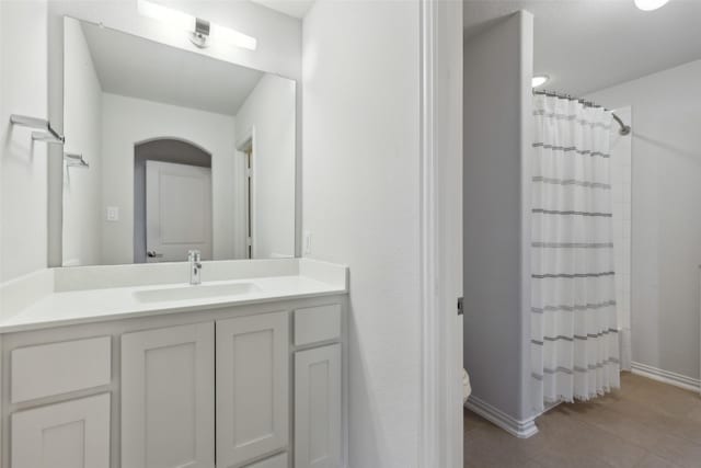 bathroom with baseboards, a shower with shower curtain, toilet, vanity, and tile patterned flooring